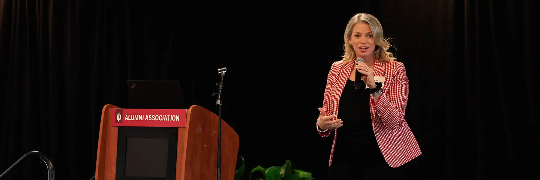 Julie Payne-Kirchmeier speaks on stage to an audience of IU Alumni Association volunteers.